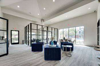Clubhouse lounge with blue velvet seating and glass partitions